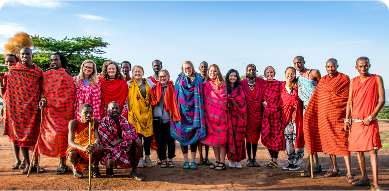 A group of people wearing colorful traditional clothing in an outdoor setting.