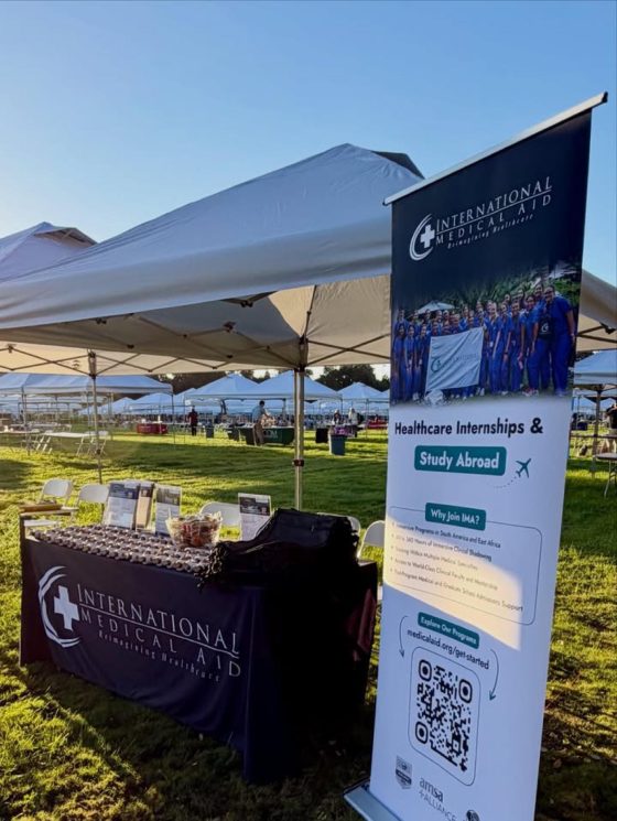 The International Medical Aid table and Healthcare Internships and Study Abroad banner with a QR code at the outdoor fair